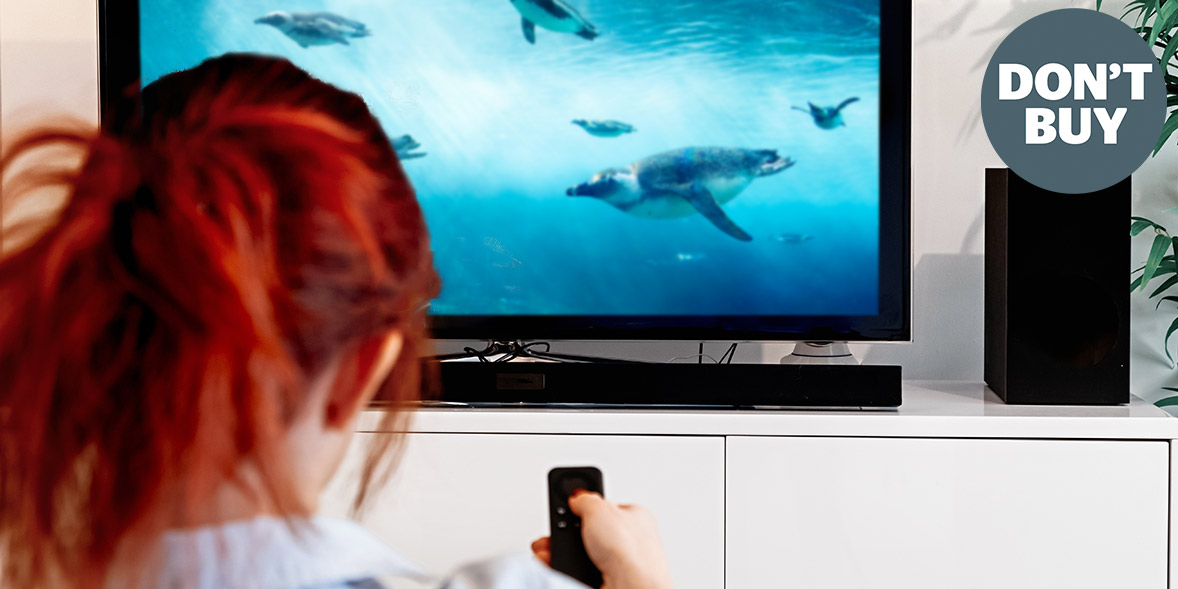 Person with red hair watching a nature documentary on TV, featuring underwater scenes with marine animals.