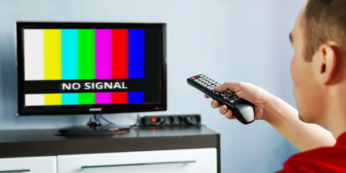 Man pointing remote at TV with 'no signal' image
