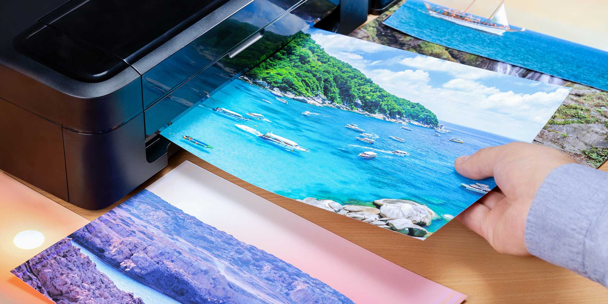 A vibrant beach scene with lush greenery, turquoise waters, and mountains, emerging from a printer onto a wooden surface.