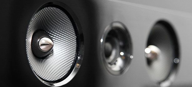 Close-up of three speaker drivers with metallic accents, featuring textured surfaces and a sleek, modern design.