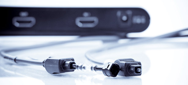 Two black cables connect to a device, with visible connectors and a sleek, dark background featuring a port.