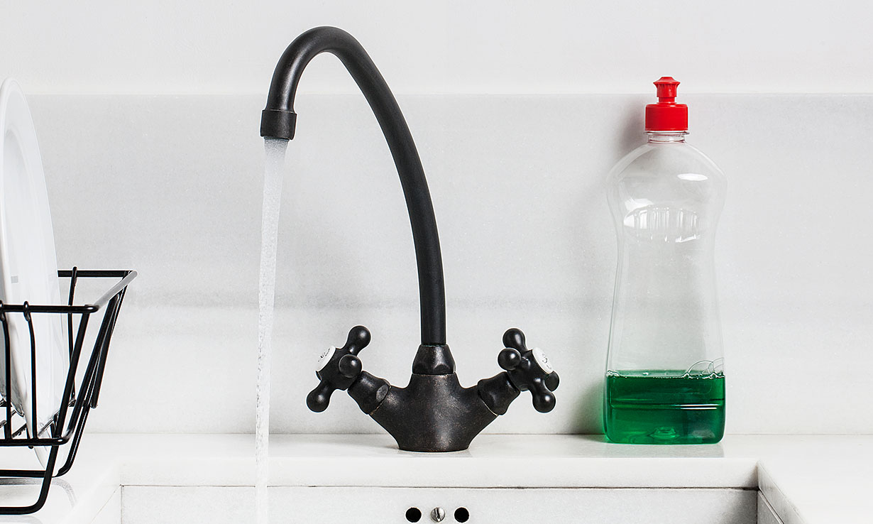 Washing up liquid next to hot water tap