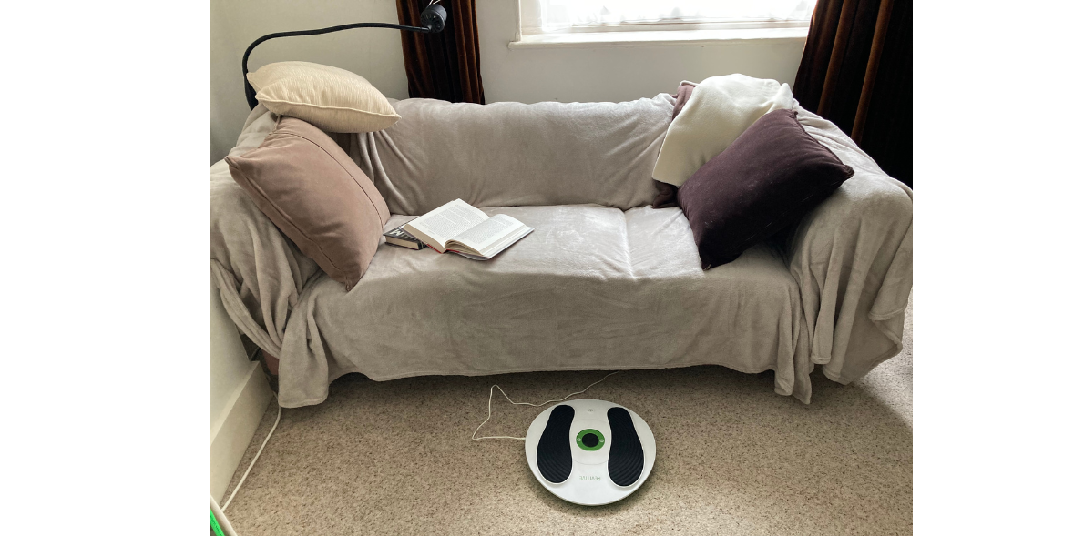 beige sofa with cushions and a circulation device on the floor in front